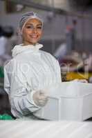 Female butcher holding container