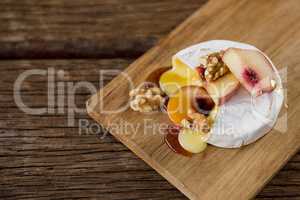 Brie cheese, with apricot and walnut pieces on serving board