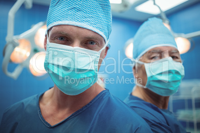 Portrait of male surgeons wearing surgical mask in operation theater