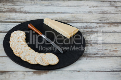 Cheese with biscuits on chopping board