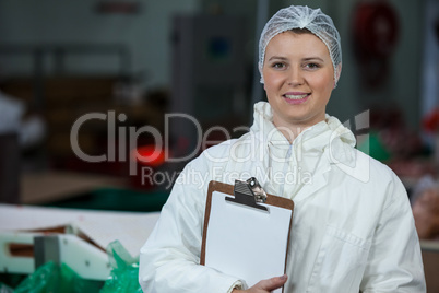 Female butcher holding clipboard