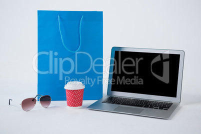 Shopping bag with sunglasses and laptop