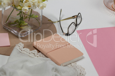 Spectacles, diary, cloth, blank page, paper balls and flowers
