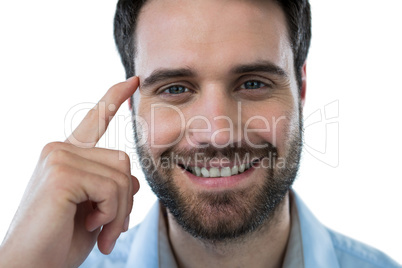 Smiling man with finger pointing to head