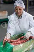 Female butcher processing sausages