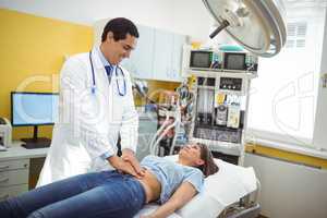 Doctor examining the stomach of a female patient