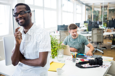 Portrait of smiling graphic designer standing with pen