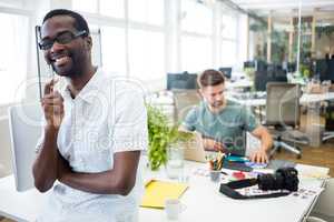 Portrait of smiling graphic designer standing with pen