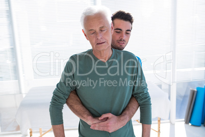 Senior patient receiving back treatment from doctor