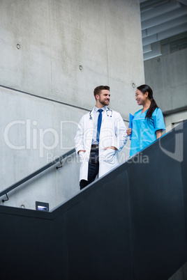 Doctor and nurse walking on stairs and talking