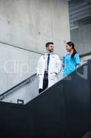 Doctor and nurse walking on stairs and talking
