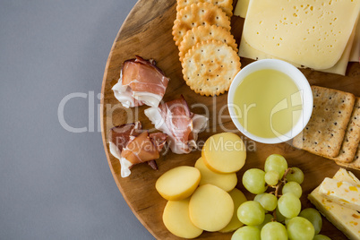 Variety of cheese with grapes, peach, meat and crackers