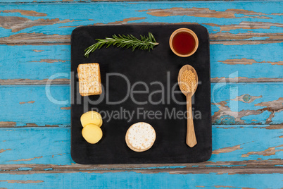 Rosemary, cheese and biscuits with spices on slate board