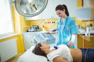 Nurse performing an electrocardiogram test on the patient