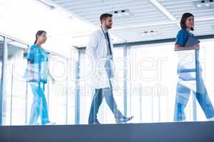 Doctor with nurses walking in corridor