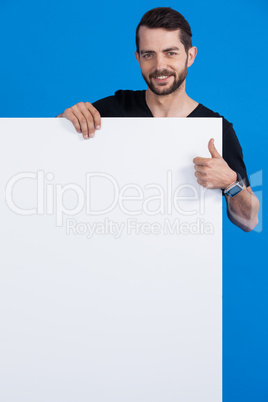 Handsome man holding a blank placard