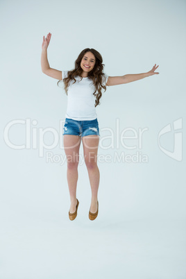Cheerful woman in white t-shirt and hot pants jumping
