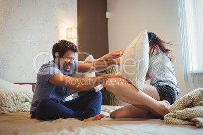 Couple having a pillow fight on bed