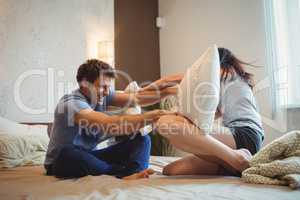 Couple having a pillow fight on bed