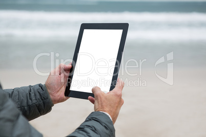 Man using digital tablet on beach