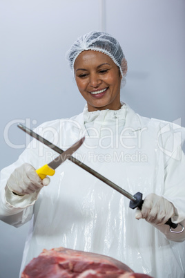 Female butcher sharpening her knife