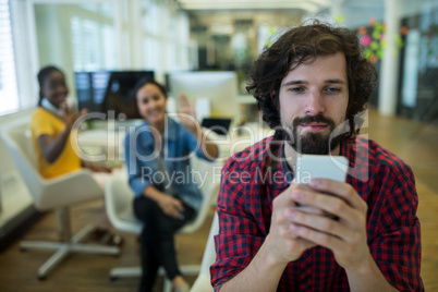 Male business executive using on mobile phone in office
