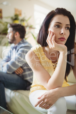 Upset couple ignoring each other on sofa