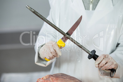 Female butcher sharpening his knife