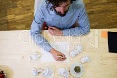 Graphic designer crumpling paper at his desk