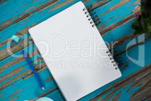 Notepad with pencil and paper clip on wooden table