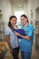 Portrait of female doctor and patient in corridor