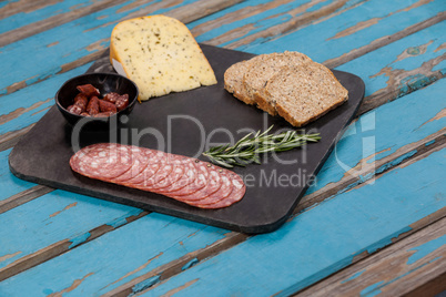Brown bread, dutch gouda cheese, rosemary and ham on slate board