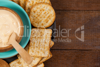 Biscuits with cheese sauce in plate on wooden table