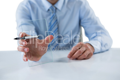 Businessman holding pen and glass sheet