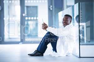 Worried doctor sitting on floor with digital tablet