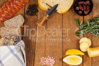 Cheese, ham and bread with various ingredients on chopping board