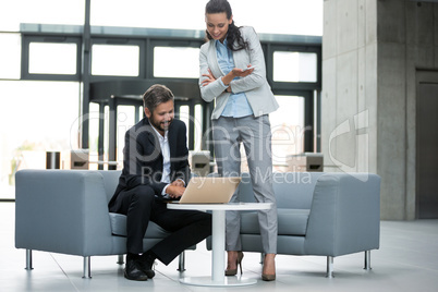 Businessman having a discussion with colleague over laptop