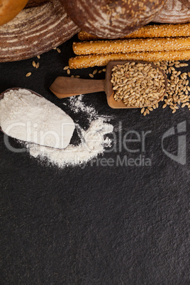 Various bread loaves with flour and wheat grains