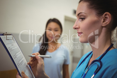 Female nurse writing on clipboard