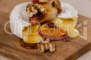 Cheese topped with walnut, fruits and sauce