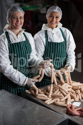 Female butchers processing sausages