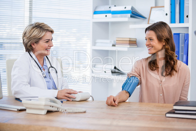 Female doctor checking blood pressure of a patient