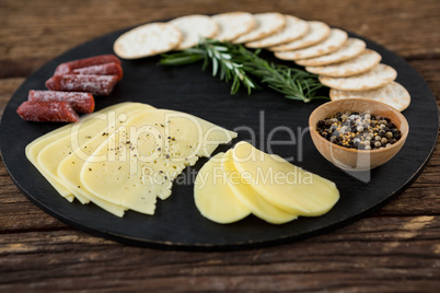 Slices of cheese, nacho chips and rosemary herbs on plate