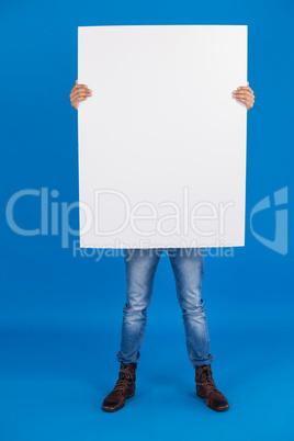 Man holding a blank placard in front of his face