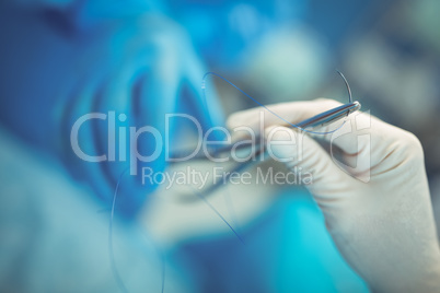 Close-up of surgeon hand holding surgical tool in operation theater