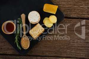 Cheese, crackers, nacho chips and rosemary herbs on slate plate