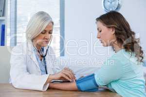 Female doctor checking blood pressure of a patient