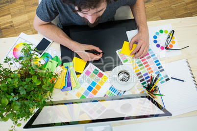 Graphic designer working on graphic tablet at his desk