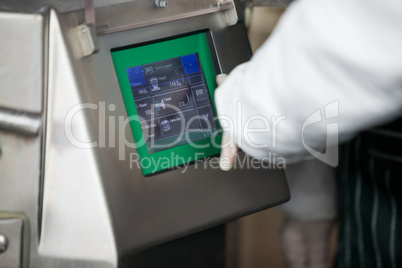 Butcher operating machine at meat factory