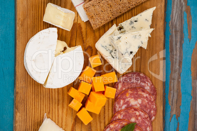 Cheese with ham and crispy biscuits on chopping board